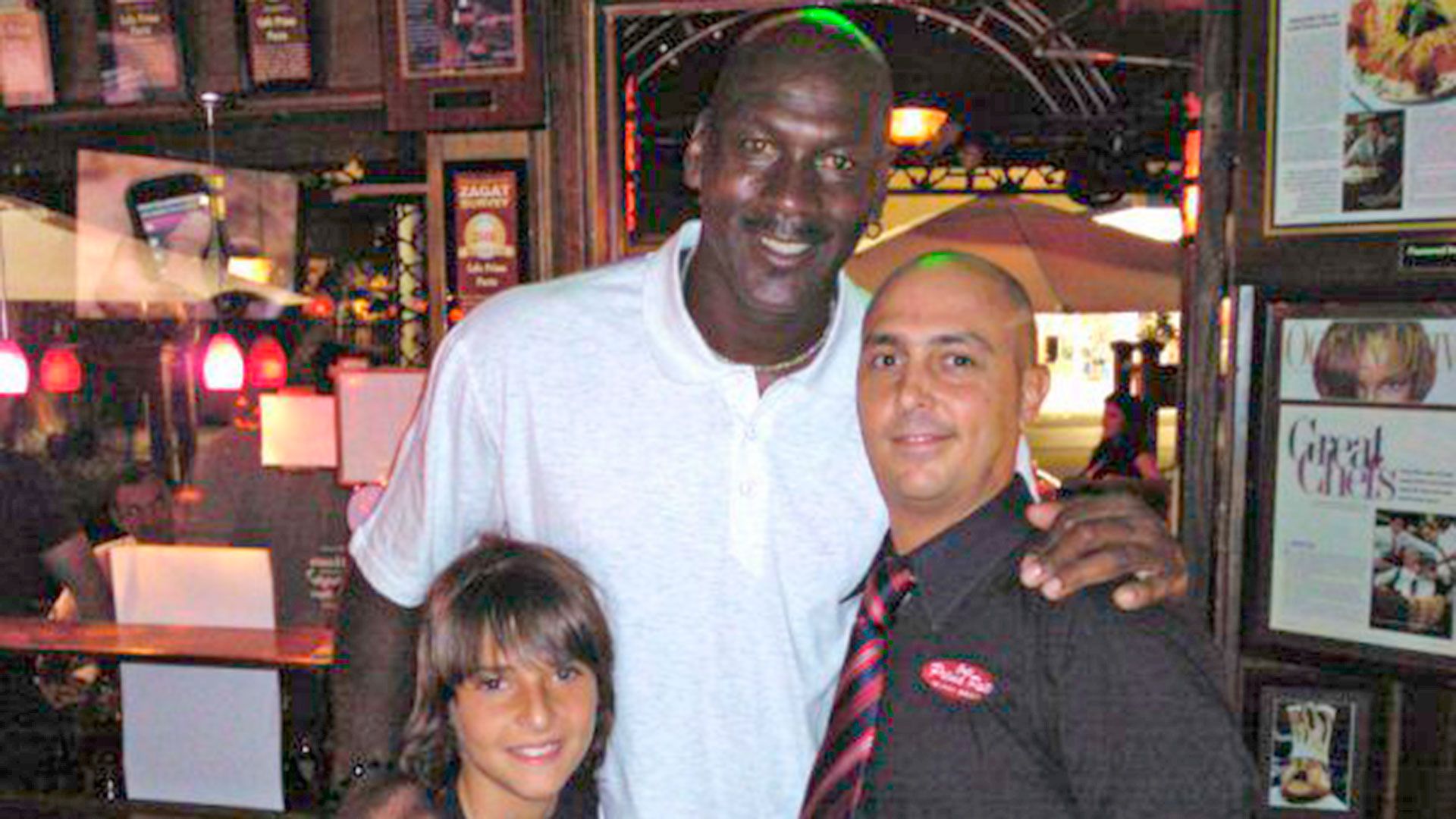 Michael Jordan junto a Lucas Cea (hijo de Gerardo) y Henry, uno de los empleados del local gastronómico (Archivo 2010)